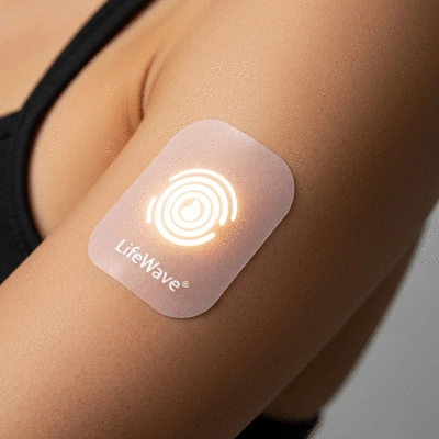 Close-up of a LifeWave phototherapy patch on a person's arm, emitting a subtle light, clean image